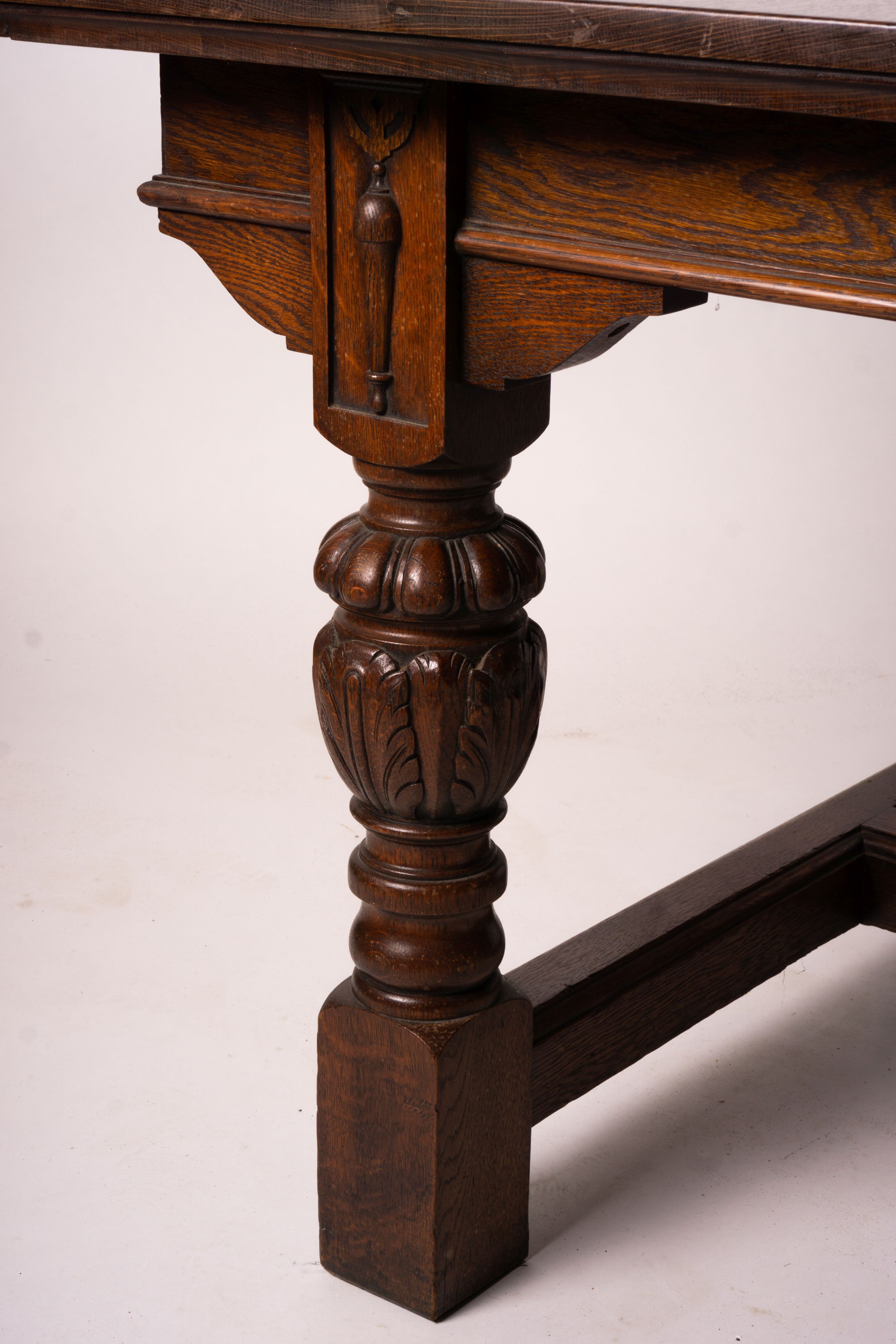 A 17th century style carved rectangular oak extending dining table with 'H' stretcher, 300cm extended, two spare leaves, width 121cm, height 75cm